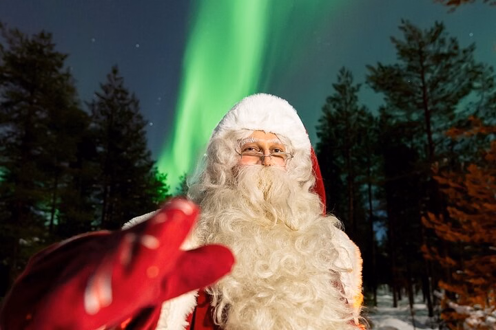 Family aurora barbecue with Santa Claus around a campfire near Rovaniemi